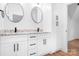 Bathroom featuring a double vanity with granite counters, white cabinets and round mirrors at 104 Arbor Dr, Waxhaw, NC 28173