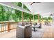 Inviting covered patio featuring wicker furniture, ceiling fan, and view of the lush backyard at 104 Arbor Dr, Waxhaw, NC 28173
