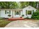 Charming single-story home featuring a well-manicured lawn and inviting curb appeal with a cozy front porch and lush greenery at 108 Greenwood Ave, Belmont, NC 28012