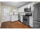 Bright kitchen featuring stainless steel appliances, white cabinetry, and a functional layout, providing an efficient cooking space at 108 Greenwood Ave, Belmont, NC 28012