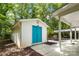 Backyard storage shed with bright blue door and ample space, adjacent to a covered patio at 108 Greenwood Ave, Belmont, NC 28012