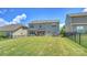 View of the spacious fenced backyard, patio, and gray two-story home at 11101 Crane Creek Dr, Charlotte, NC 28278