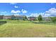 Wide shot of the backyard featuring lush grass, a black fence, and neighborhood homes under a sunny sky at 11101 Crane Creek Dr, Charlotte, NC 28278