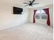 Bright bedroom featuring neutral walls, carpet, ceiling fan and a large window with red curtains at 11101 Crane Creek Dr, Charlotte, NC 28278