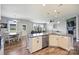 Kitchen island with sink, white cabinets, with view of dining area and stone fireplace at 11101 Crane Creek Dr, Charlotte, NC 28278