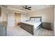Cozy bedroom featuring a tray ceiling, ceiling fan, neutral walls, carpet and ensuite bathroom at 11101 Crane Creek Dr, Charlotte, NC 28278