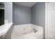Bathroom featuring soaking tub with tile surround and chrome fixtures at 1111 Lizzie Ln, Salisbury, NC 28147