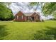 Charming red brick home with manicured lawn and landscaping under a partly cloudy sky at 1111 Lizzie Ln, Salisbury, NC 28147