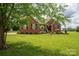 A brick home with dark shutters has a green lawn with mature trees at 1111 Lizzie Ln, Salisbury, NC 28147