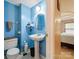 Stylish bathroom with a sleek pedestal sink, blue walls, and well-placed fixtures at 11718 Battery Pl, Charlotte, NC 28273