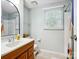Well-lit bathroom featuring a wood vanity, neutral walls, and large window at 11718 Battery Pl, Charlotte, NC 28273