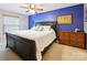 Primary bedroom featuring blue accent wall, carpeted floor, ceiling fan, and dresser at 11718 Battery Pl, Charlotte, NC 28273