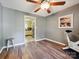 Neutral bedroom featuring wood floors, a ceiling fan, and a view to an adjacent kitchen at 11718 Battery Pl, Charlotte, NC 28273