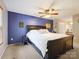 Primary bedroom with blue accent wall, ceiling fan, and a glimpse of an ensuite bathroom at 11718 Battery Pl, Charlotte, NC 28273