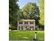 Charming two-story home with a well-manicured front lawn, blue door, and classic black shutters on a sunny day at 11718 Battery Pl, Charlotte, NC 28273