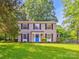 Charming two-story home featuring a bright blue door, black shutters, and a well-maintained front lawn at 11718 Battery Pl, Charlotte, NC 28273