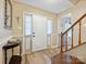 Warm and inviting foyer with wood floors, staircase, and a decorative accent table at 11718 Battery Pl, Charlotte, NC 28273