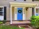 Inviting front entrance with a bright blue door, a decorative wreath, and manicured landscaping at 11718 Battery Pl, Charlotte, NC 28273