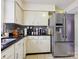 A kitchen featuring white cabinets, stainless steel fridge, and black granite counters at 11718 Battery Pl, Charlotte, NC 28273