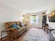 Bright living room with hardwood floors, a comfortable sofa, and a large window providing ample natural light at 11718 Battery Pl, Charlotte, NC 28273