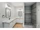 Modern bathroom featuring double vanities with granite counters and a stand alone shower with black fixtures at 12382 Ritchie Rd, Midland, NC 28107