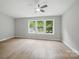 Bright bedroom featuring a ceiling fan, and multiple windows offering natural light and an outside view at 12382 Ritchie Rd, Midland, NC 28107