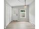 Bright entryway featuring a modern light fixture, door, window, and closet for practical storage at 12382 Ritchie Rd, Midland, NC 28107