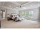Expansive main bedroom with a tray ceiling, a seating area, and lots of natural light at 13102 Indigo Run Ct, Charlotte, NC 28278