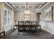 Elegant dining room with decorative wallpaper, coffered ceiling, and modern chandelier at 13102 Indigo Run Ct, Charlotte, NC 28278