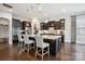 Elegant kitchen featuring a large island with seating, stainless steel appliances, and dark wood cabinetry at 13102 Indigo Run Ct, Charlotte, NC 28278