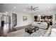Open living room area showcasing hardwood floors, a ceiling fan, and a view of the kitchen at 13102 Indigo Run Ct, Charlotte, NC 28278