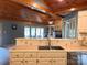 Kitchen boasts stainless appliances, white cabinetry, and stylish tile backsplash, with wood ceiling detail at 1351 Hardin Rd, Dallas, NC 28034