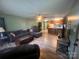 Open concept living room featuring hardwood floors, a large sofa, and a ceiling fan, with an open kitchen in the background at 1351 Hardin Rd, Dallas, NC 28034