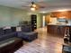 Open concept living room featuring hardwood floors, a large sofa, and a ceiling fan, with an open kitchen in the background at 1351 Hardin Rd, Dallas, NC 28034