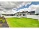 Large grassy backyard featuring a covered patio and white vinyl fence at 13702 Tranquil Day Dr, Matthews, NC 28105