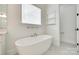 Modern soaking tub with window in a neutral, bright bathroom at 13702 Tranquil Day Dr, Matthews, NC 28105
