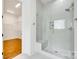 Glass shower with built in bench and tile surround leading to walk-in closet at 13702 Tranquil Day Dr, Matthews, NC 28105
