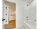Bright bathroom featuring a shower-over-tub with white tile, and wood-look flooring at 13702 Tranquil Day Dr, Matthews, NC 28105