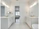 Modern bathroom with double sinks, tile floor, and views to the bedroom at 13702 Tranquil Day Dr, Matthews, NC 28105