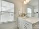 Well-lit bathroom featuring a large vanity, quartz countertop, soft-close drawers, and a view from the window at 13702 Tranquil Day Dr, Matthews, NC 28105