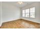 Bright bedroom featuring hardwood floors, ceiling fan, and large window at 13702 Tranquil Day Dr, Matthews, NC 28105