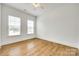 Bright bedroom with hardwood floors, two windows, and a ceiling fan at 13702 Tranquil Day Dr, Matthews, NC 28105