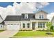 Charming two-story home with a manicured lawn, attached garage, and inviting front porch at 13702 Tranquil Day Dr, Matthews, NC 28105