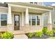Inviting front porch with brick accents, sturdy columns, and manicured landscaping at 13702 Tranquil Day Dr, Matthews, NC 28105