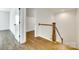 Bright hallway with hardwood floors and a staircase featuring wood railings and white spindles that adds character at 13702 Tranquil Day Dr, Matthews, NC 28105