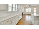 Bright, open kitchen features white cabinets, stone countertops, and leads to the living area with a fireplace at 13702 Tranquil Day Dr, Matthews, NC 28105