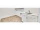 Well-lit laundry room featuring a new sink, white cabinets, modern fixtures and attractive herringbone-patterned floors at 13702 Tranquil Day Dr, Matthews, NC 28105