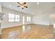 A bright living room featuring wood floors, a ceiling fan, and lots of natural light at 13702 Tranquil Day Dr, Matthews, NC 28105