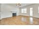 Bright living room with a fireplace, hardwood floors, a ceiling fan, and lots of natural light at 13702 Tranquil Day Dr, Matthews, NC 28105
