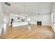 An open concept living space flows between the kitchen and living room with fireplace, wood floors and natural light at 13702 Tranquil Day Dr, Matthews, NC 28105